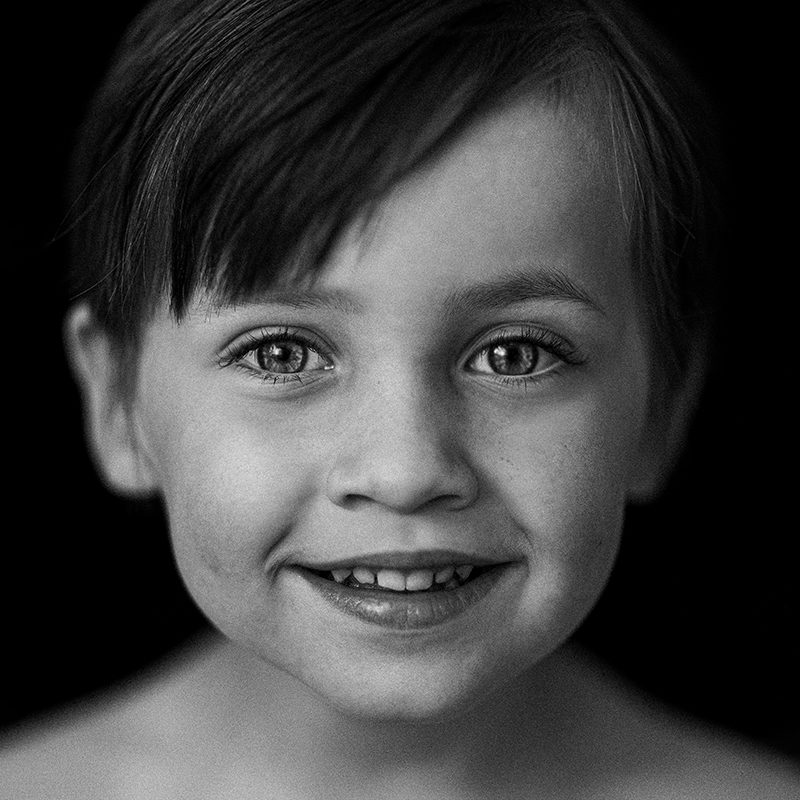 A boy staring at the camera, photographed in black and white