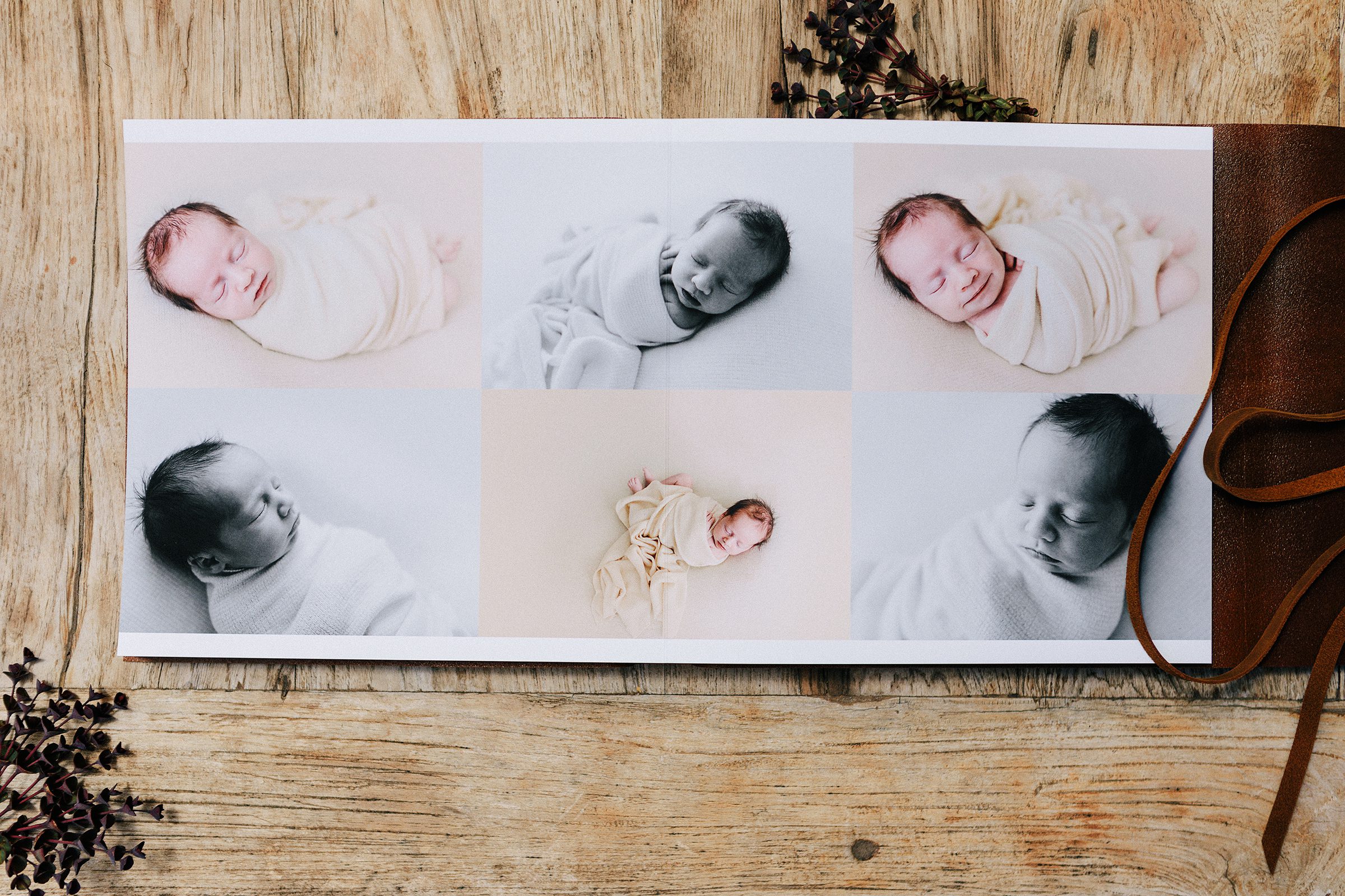 Lay-flat newborn photo album displaying softly lit baby portraits