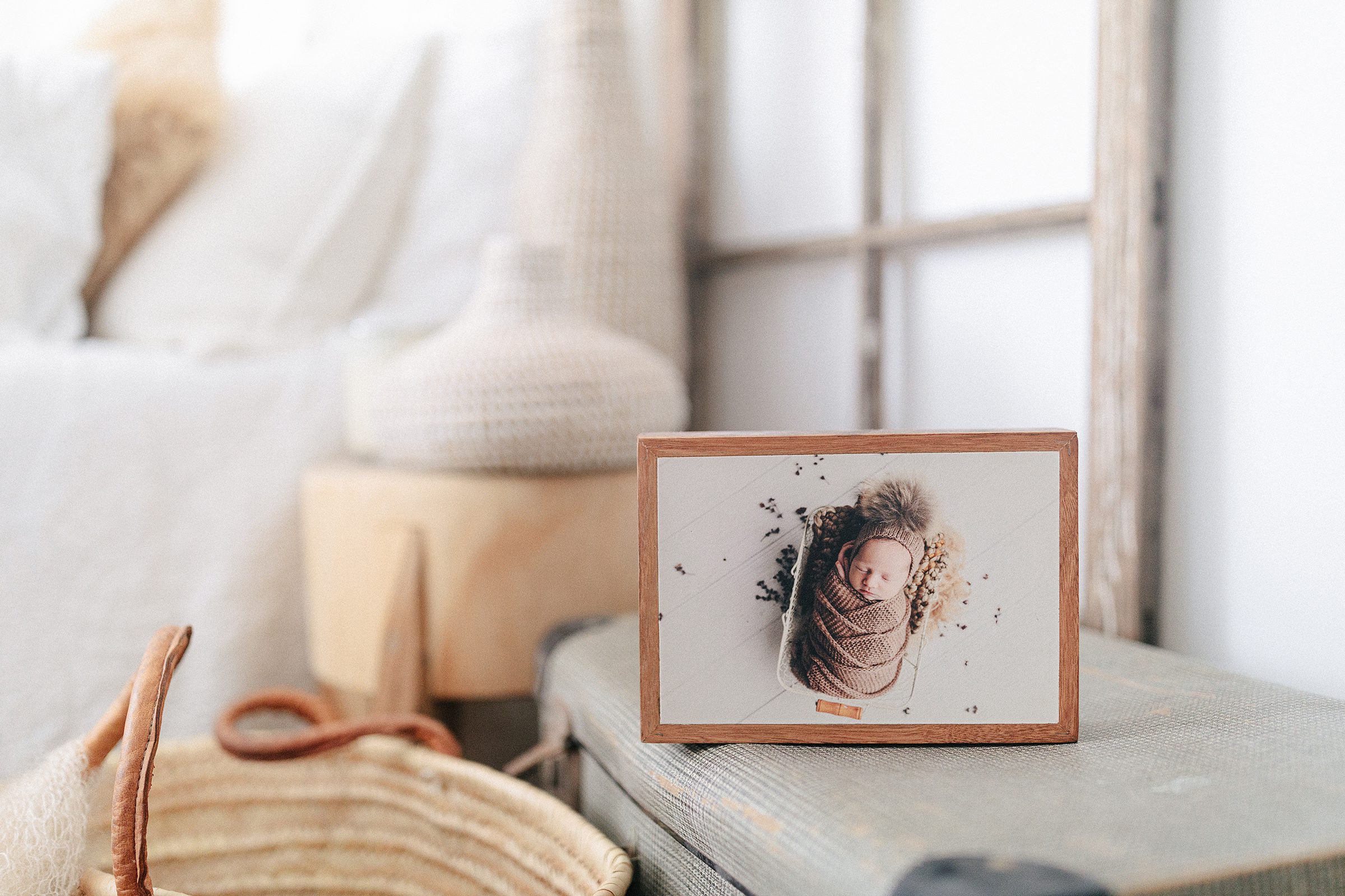 Framed newborn photo sitting on table top