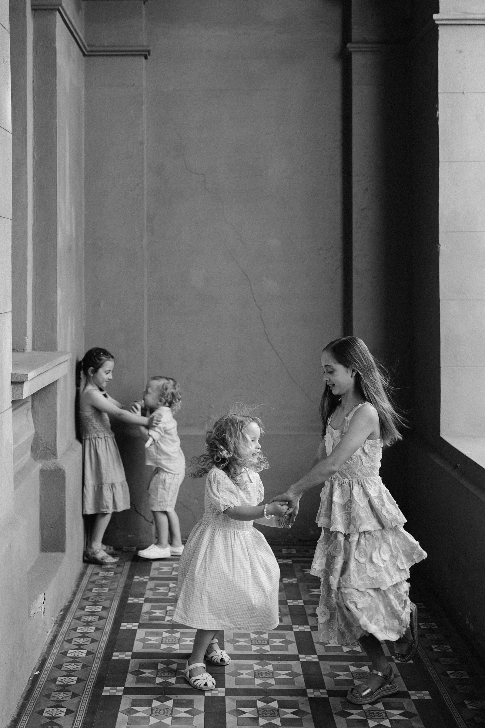 Children playing between portraits during an extended family photo session in Perth