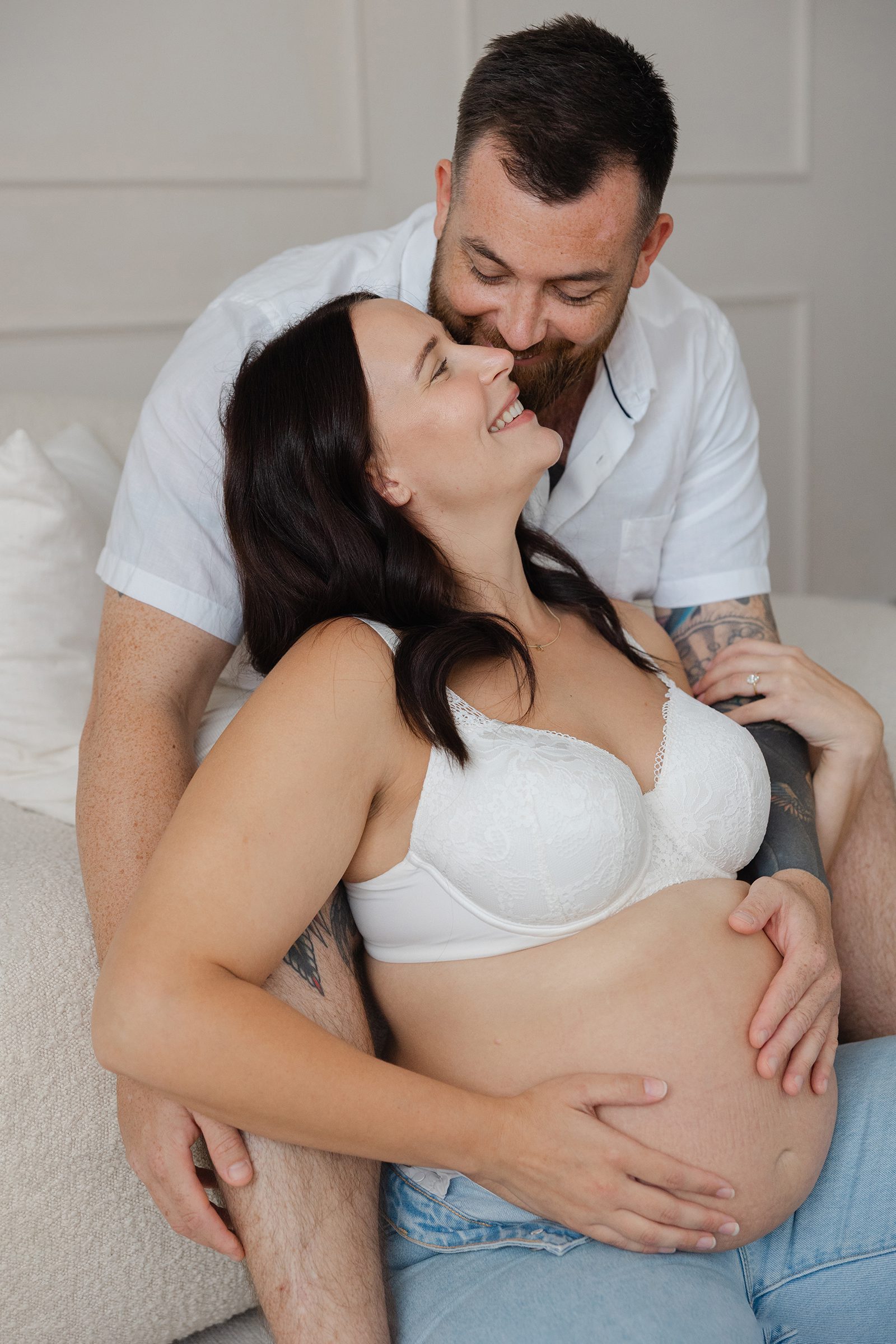 A partner lovingly connects with baby and mum in a quiet, emotional moment during a Perth outdoor maternity shoot