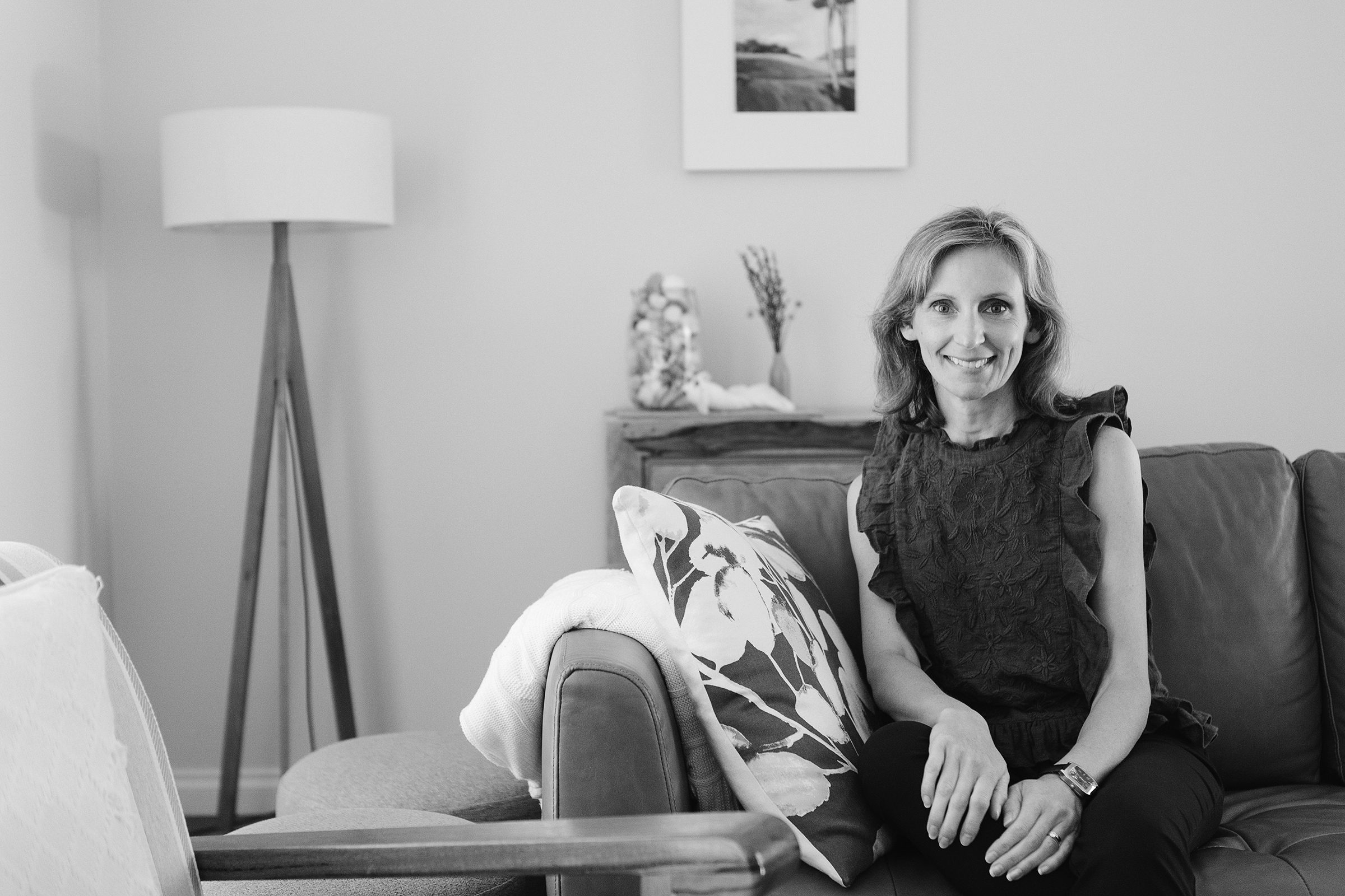 Woman smiling in a light-filled home office during personal branding session with Perth photographer.